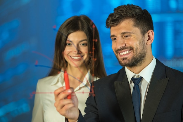 The happy man and woman drawing on the virtual screen