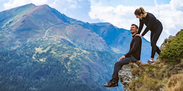 The happy man and a woman enjoying on the beautiful cliff