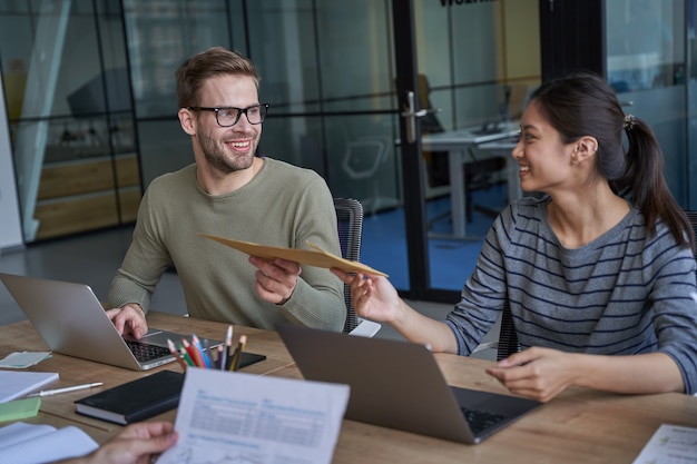 Happy man and woman looking and holding envelope