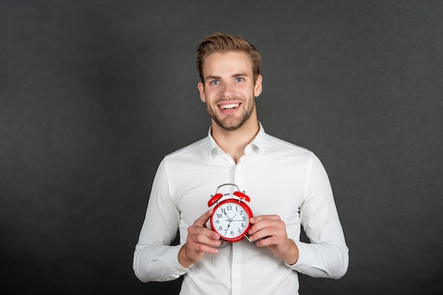 Happy manager hold alarm clock. Business punctuality.