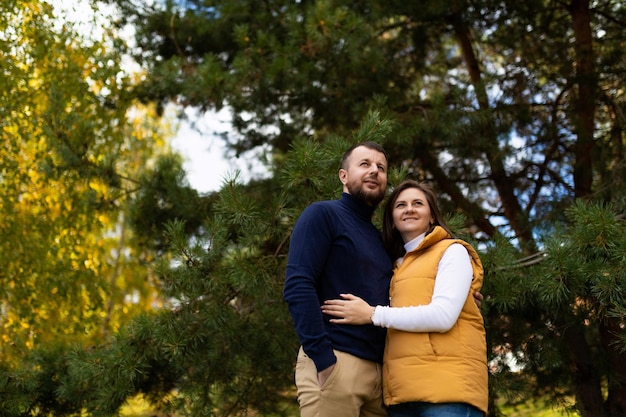 Happy married couple hugging in autumn forest