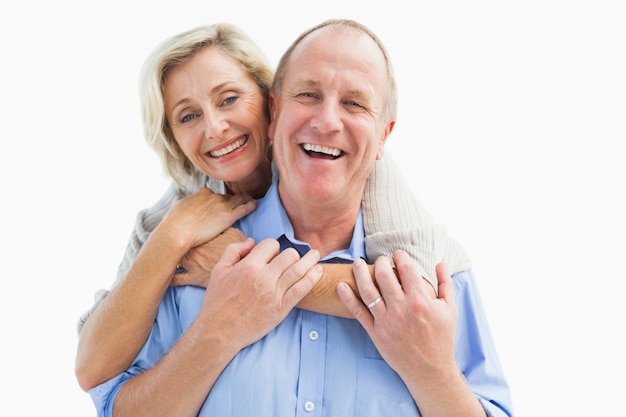 Happy mature couple embracing smiling at camera