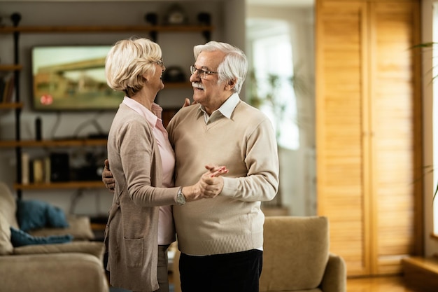 Happy mature couple enjoying while dancing at home