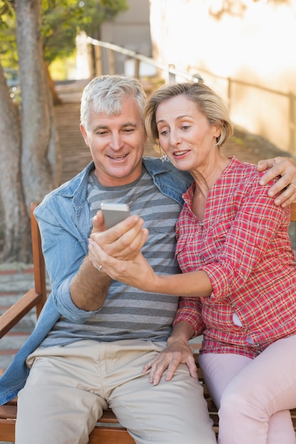 Happy mature couple taking a selfie together in the city