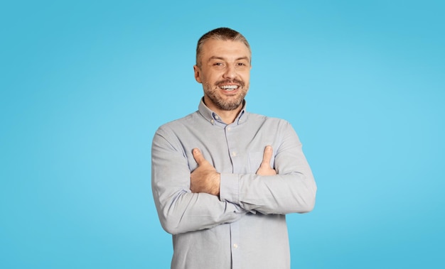 Happy Mature Male Smiling To Camera Standing On Blue Background