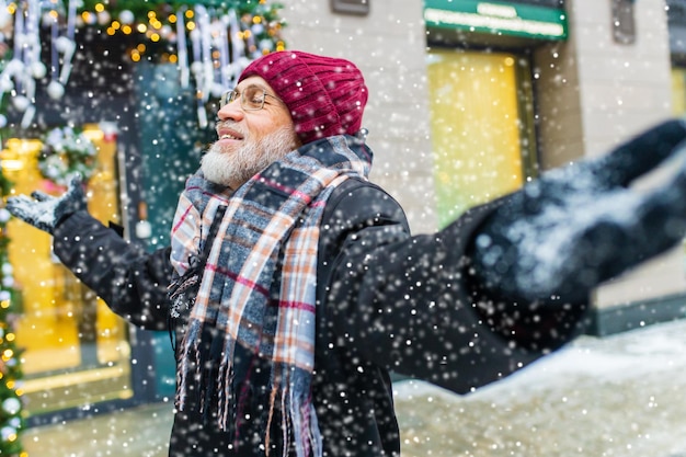 Happy mature man in winter christmas market outdoors with cityscape in the background