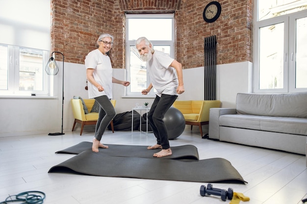 Happy mature man and woman dancing at home