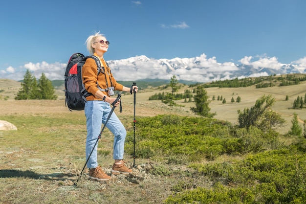 Happy mature woman hiking in the mountains concept adventure autumn vacations outdoor active lifestyle