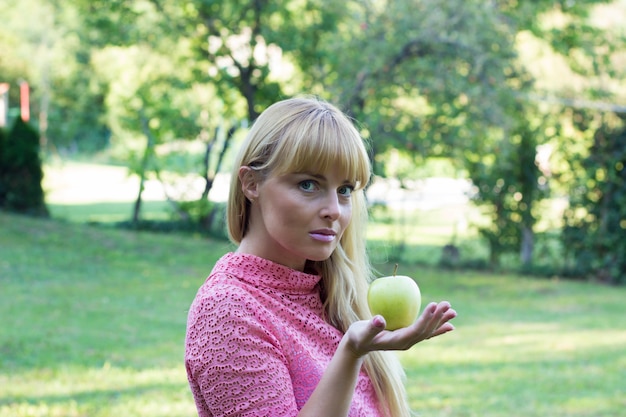 Happy mature woman with green apple