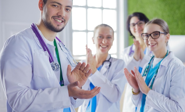 Photo happy medical team comprising male and female doctors smiling broadly and giving a thumbs up of success and hope