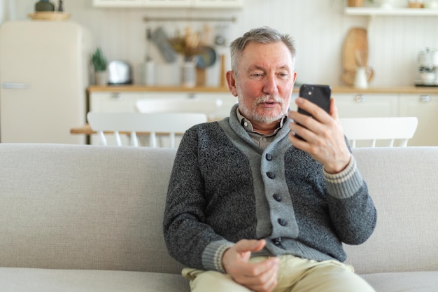 Happy middle aged senior man talk on video call with friends family laughing mature old senior grand