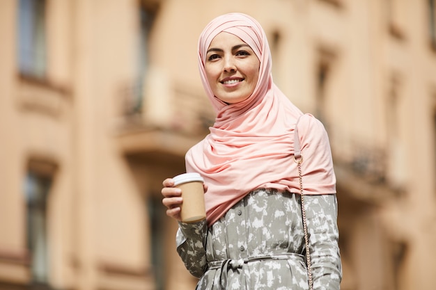 Happy middle-eastern businesswoman with coffee cup