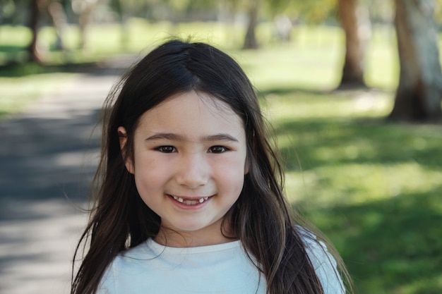 Happy mixed Asian girl missing her front milk teeth smiling with confident in the park, Child oral health and dental care 