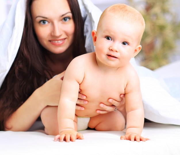 Happy mom and her baby are playing at home