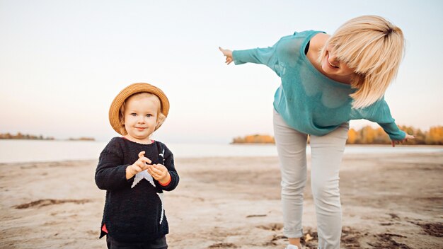 Happy mom with daughter have fun on the beach