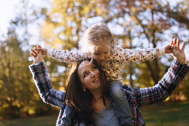 Happy mom with little daughter in autumn park outdoor recreation Mom and daughter