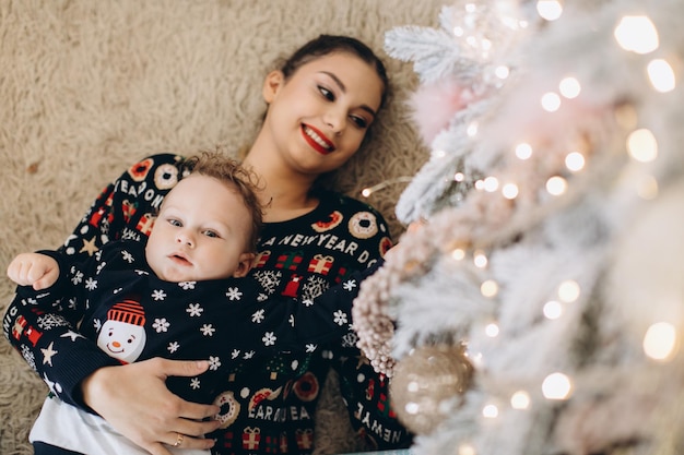 Happy mother and baby little son playing home on Christmas holidays New Year's holidays