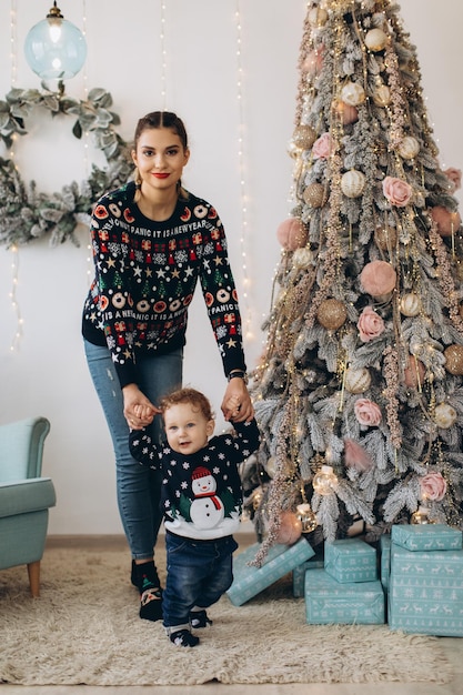 Happy mother and baby little son playing home on Christmas holidays New Year's holidays