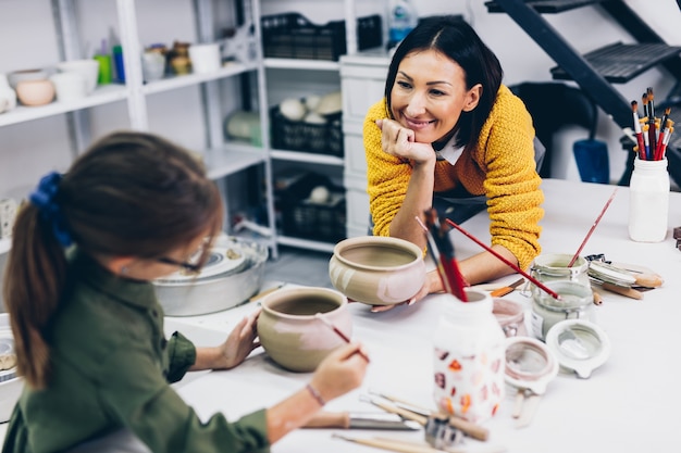 Happy mother and daughter enjoying together in making clay pottery.