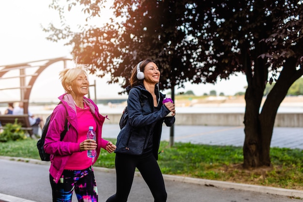 Happy mother and daughter enjoying in walk outdoors in park.