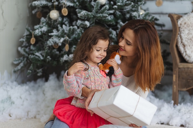 Happy mother and daughter holding Christmas gift