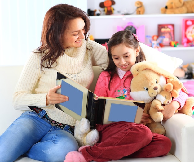 Happy mother and daughter reading a book together