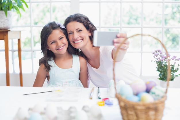 Happy mother and daughter taking selfie