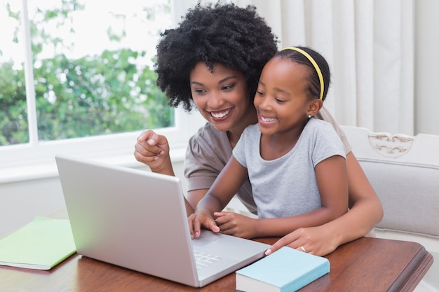 Happy mother and daughter using the laptop