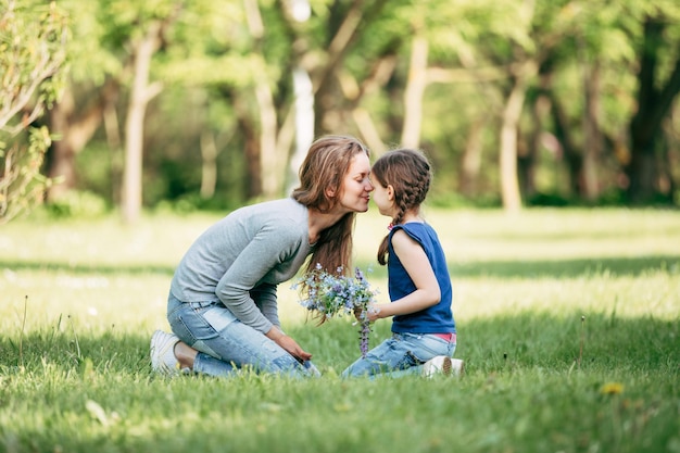 Happy mother and daughter with a bouquet of wildflowers