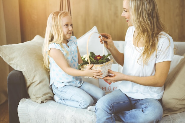 Happy mother day. Child daughter congratulates mom and gives her basket of spring flowers. Family concept