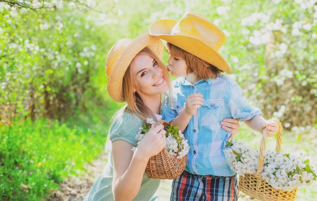 Happy mother family with son at picnic basket with blossom bloom flowers family mom with kid sitting