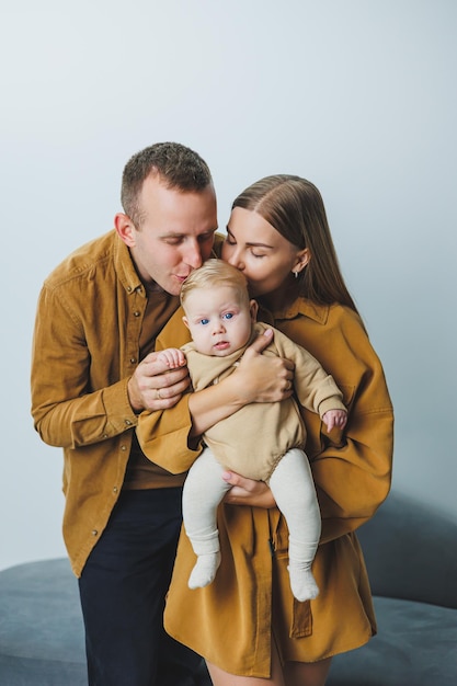 A happy mother and father hold their 4monthold son in their arms Family photo of happy parents with a newborn baby Family concept