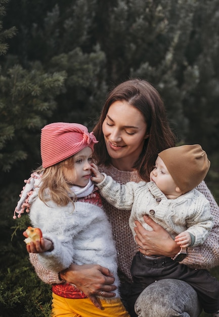 Happy mother and her son and doughter on nature smiling play and embracing Love and tenderness International hugging day