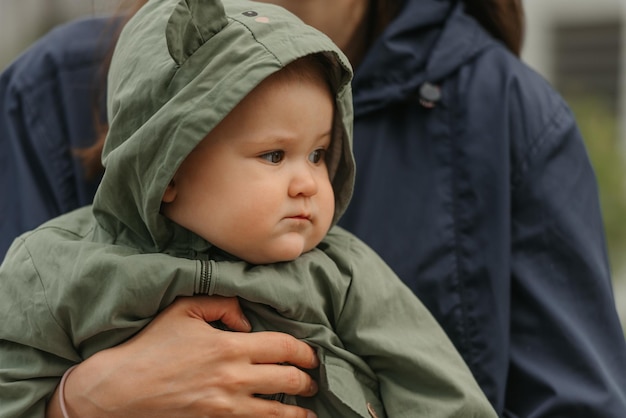 A happy mother is holding her young daughter on a cloudy day