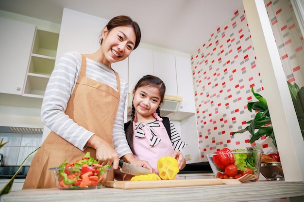 Happy Mother and kid preparing healthy food and having fun in kitchen at home