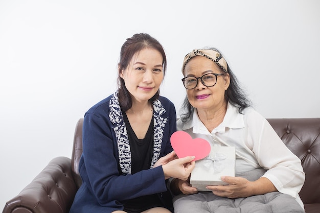 Happy mother's day Beautiful young woman and her mother with a gift box at home