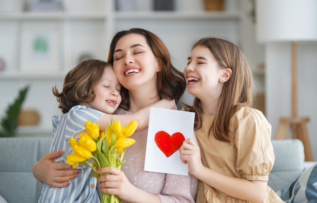 Happy mother's day Mum and girls smiling and hugging Family holiday and togetherness