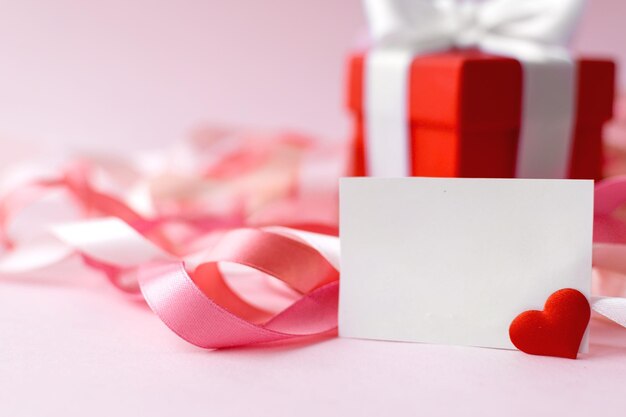 Happy Mother's Day or women's day Red box with gift and white greeting card on a pink background