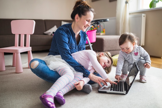 Happy mother with her children working on laptop