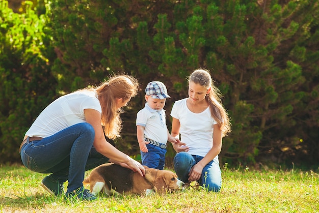 Photo happy mother with her daughter, little son and beagle dog for a walk