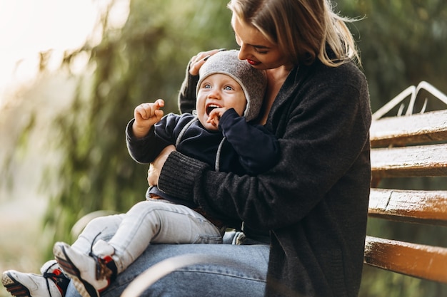 Happy mother with her little baby son having fun in the park