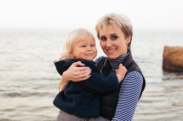 Happy mother with son on a sunny day near sea Rest on the beach A happy family