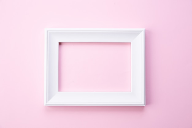 Happy Mothers day concept. Top view of white picture frame on pink background