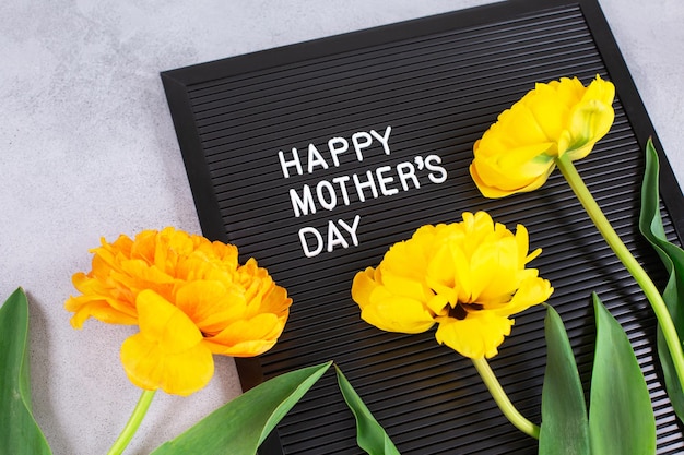 Happy mothers day words and yellow tulips