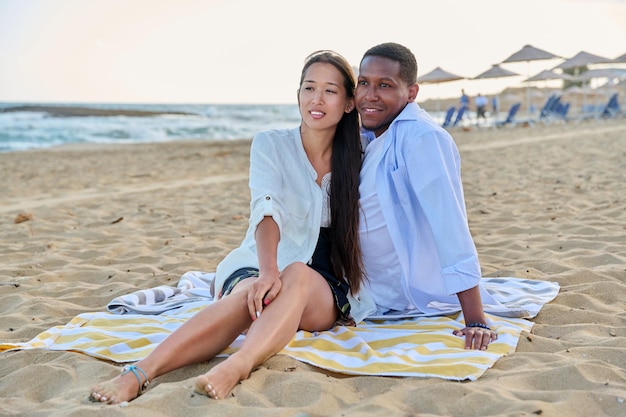 Happy multiethnic family having a rest on the beach together