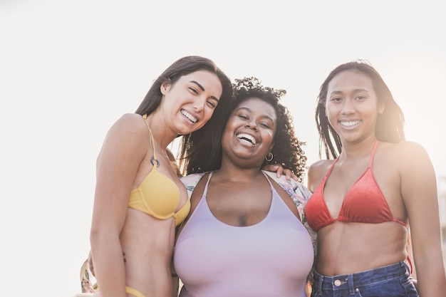 Happy multiethnic women enjoy day on the beach during summer vacation