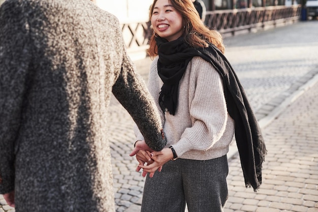 Happy multiracial couple together outdoors in the city. Asian girl with her caucasian boyfriend.