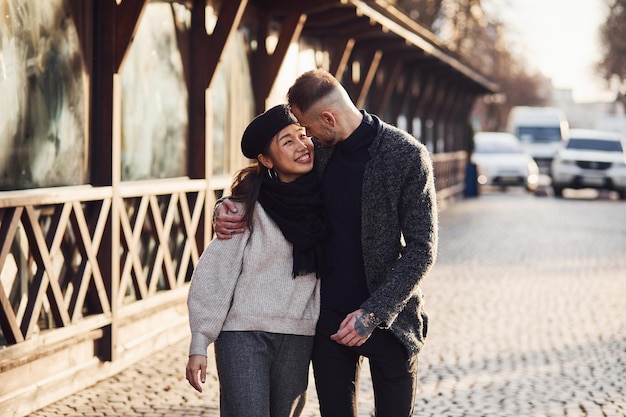 Happy multiracial couple together outdoors in the city. Asian girl with her caucasian boyfriend.