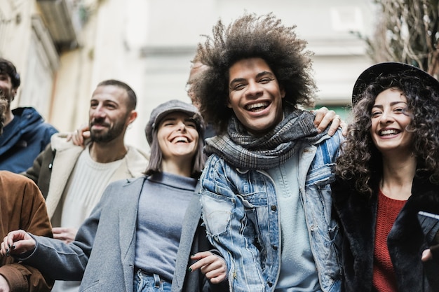 Happy multiracial friends having fun outdoor in the city - Focus on african man face