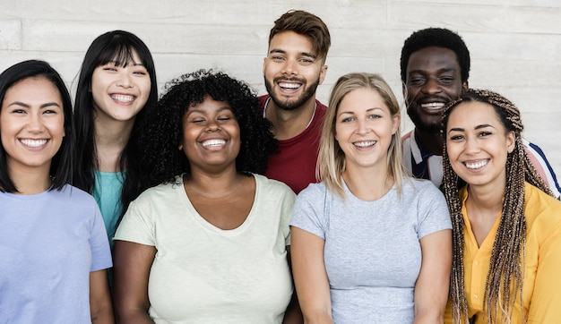 Happy multiracial friends having fun together looking at camera outdoor - Main focus on african girl face